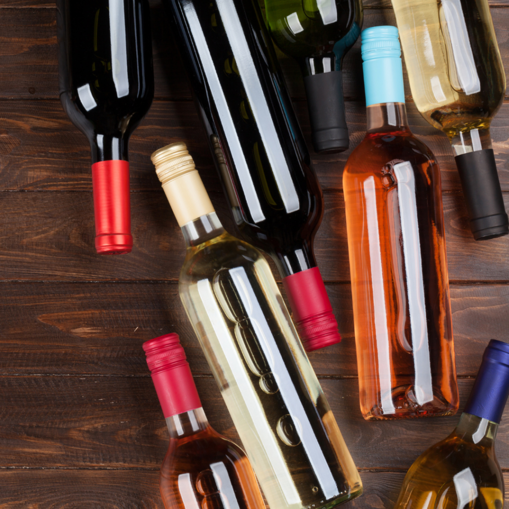 PBS bottling your wine blog - a collection of bottles with unmarked wine on a wood table background